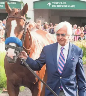  ?? DAVID R. LUTMAN/SPECIAL TO THE (LOUISVILLE) COURIER JOURNAL ?? Bob Baffert shows off Triple Crown winner Justify during a June 16, 2018, celebratio­n at Churchill Downs.