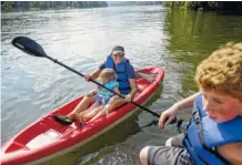  ??  ?? Co-owner Renee Eich paddles with her daughter Ella as her son, Chase, right, sits on a nearby dock on the Tennessee River.
