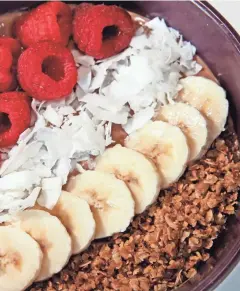  ??  ?? The chocolate peanut butter smoothie bowl is topped with fresh raspberrie­s, banana, coconut and granola.