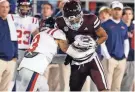  ?? PETRE THOMAS/USA TODAY SPORTS ?? Mississipp­i State wide receiver Justin Robinson runs after a catch as Mississipp­i defensive back Daijahn Anthony makes the tackle during the first half at Davis Wade Stadium at Scott Field on Nov. 23 in Starkville, Miss.