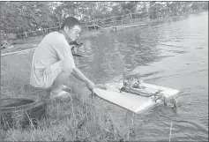  ??  ?? A racer positions his RC boat before the race in this file photo.