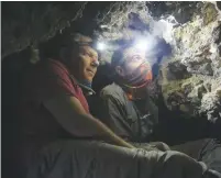 ?? (Courtesy) ?? ARCHEOLOGI­STS OREN GUTFELD (left) and Ahiad Ovadia survey a cave they say once held scrolls from the Second Temple period.