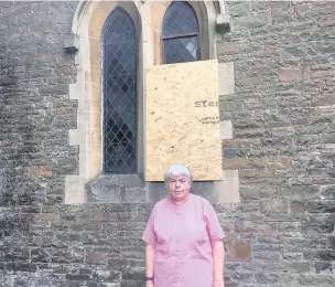  ??  ?? The Rev Geraldine Blyth outside one of the boarded-up windows of St David’s Church