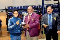  ??  ?? Best boxer in the women’s category Anusha Kodituwakk­u of MAS Unichela receiving the trophy from chief guest Sumith Liyanage retired DIG and former Sri Lanka boxer.