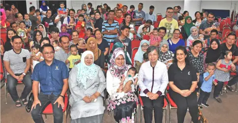  ??  ?? Fatimah (seated centre, carrying a baby) poses with (seated from left) Zulkarnain, Arpah and Dr Ngian and the recipients of ‘Reading Seeds’ kits at Sibu Civic Centre.