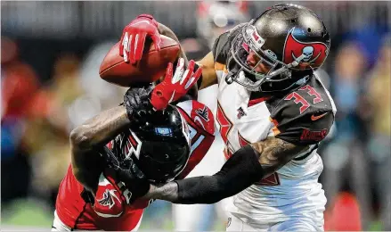  ?? CURTIS COMPTON / CCOMPTON@AJC.COM ?? Bucs cornerback Carlton Davis III strips Calvin Ridley of the ball in Sunday’s third quarter in Atlanta as the Falcons struggled to get anything going on offense. Ridley redeemed himself, catching a Matt Schaub TD pass in the fourth quarter.