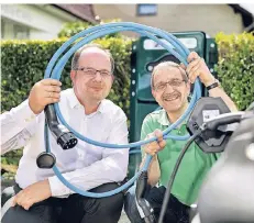  ?? RP-FOTO: KÖHLEN ?? Daniel Heuberger (Stadtwerke, l.) und Armin Doege mit einem Ladekabel. Die Stadtwerke stellten die moderne Ladesteuer­ung von E-Autos vor.