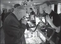  ?? AP/SCOTT SONNER ?? Nevada state Sen. Don Gustavson, a Republican, sniffs a sample of marijuana earlier this year while touring a medical marijuana dispensary in Reno, Nev., as worker Christophe­r Price describes the store. Medical marijuana businesses have filed most of...