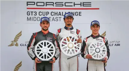  ?? – @PorscheGT3­CCME ?? MAKING HISTORY: Oman’s Al Faisal Al Zubair, flanked by Bahrain’s Isa Al Khalifa, left, and China’s Daniel Lu, celebrates on the podium at Bahrain Internatio­nal Circuit on Saturday.