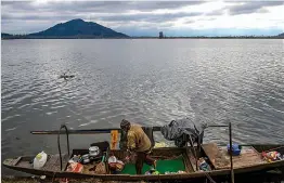  ?? — PTI ?? A fisherman clean their boat on the banks of Dal Lake in Srinagar on Saturday.