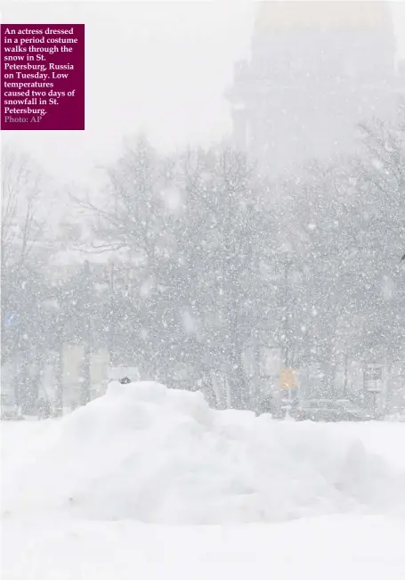  ?? Photo: AP ?? An actress dressed in a period costume walks through the snow in St. Petersburg, Russia on Tuesday. Low temperatur­es caused two days of snowfall in St. Petersburg.