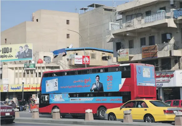  ?? AFP ?? A bus in Baghdad displays a poster advising people to check their voting informatio­n in time for Iraq’s parliament­ary elections, which are scheduled for May