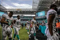  ?? BILL INGRAM / THE PALM BEACH POST ?? Miami Dolphins players exit the field during the second weather delay, this one in the third quarter, against the Tennessee Titans on Sunday in Miami Gardens.