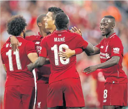  ??  ?? Liverpool’s Roberto Firmino, centre, celebrates with teammates after scoring against Torino in a pre-season game at Anfield.