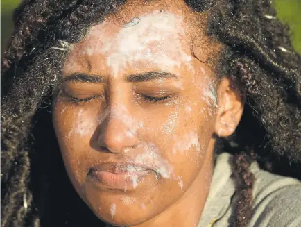  ??  ?? Kana Abera, 17, of Denver, has her face covered in tear gas at Friday’s protest downtown.