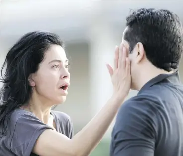  ?? MARK MULLIGAN / THE ASSOCIATED PRESS ?? Jennifer Molleda looks at her husband, Alan Wakim, after two bullets flew past his head during a shooting spree early Monday that injured nine people in a Houston neighbourh­ood. The alleged shooter was later killed by police.