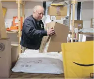  ??  ?? Crow Smith handles packages in a corner in one of his three warehouses in Ogdensburg, New York, that has been devoted to parcels that Canadians order online.