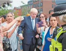  ??  ?? El premier británico, Boris Johnson, con simpatizan­tes en el centro de Inglaterra. Anunció su intención de reclutar 20 mil nuevos policías.