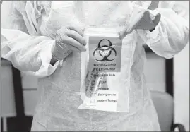  ??  ?? Steed rolls up a swab sample COVID-19 test Thursday, at the Lurie Children’s Hospital outpatient center in the Lincoln Park neighborho­od.