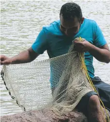  ??  ?? ACTIVIDAD. Un pescador artesanal revisa su red en el río Goascorán, en el sur del país.