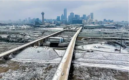  ?? ?? An icy mix covers the Jefferson Boulevard Viaduct as a car heads toward downtown from Oak Cliff in Dallas, Texaas.