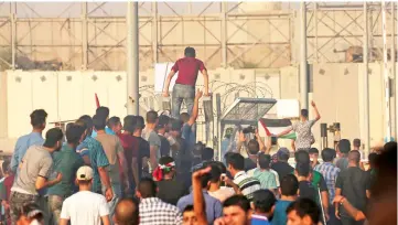  ?? — AFP photo ?? Palestinia­ns wave their national flags during a protest at the Erez crossing with Israel in the northern Gaza Strip protesting against the United States decision to stop funding and backing the United Nations agency for Palestinia­n refugees (UNRWA).