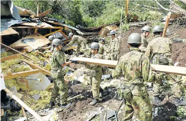  ?? Picture: JAPAN SELF-DEFENCE FORCES/VIA REUTERS ?? GRIM SEARCH: Members of the Japan Self-Defence Forces search for survivors from a house damaged by a landslide caused by an earthquake in Atsuma, on Japan’s northern Hokkaido island