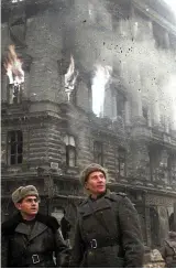  ?? ?? Above left: Two Russian soldiers surveying the ruins as Berlin burns during the final days of the Third Reich