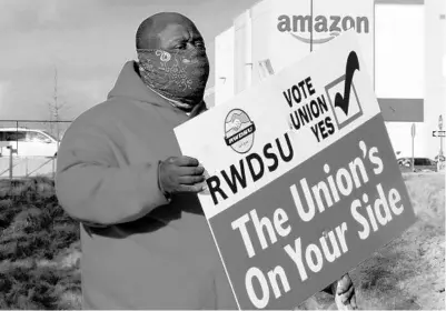  ?? JAY REEVES/AP ?? Michael Foster holds a sign outside an Amazon warehouse where labor is trying to organize workers in Bessemer, Alabama.