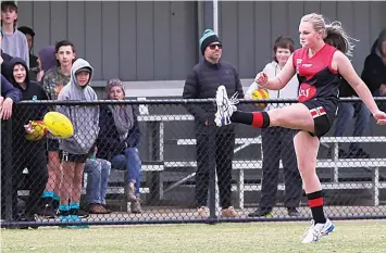  ?? ?? Warragul’s Riley Trewin kicks the ball as the crowd at Western Park watches on.