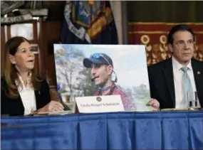  ?? AP PHOTO/HANS PENNINK, FILE ?? Linda Beigel Schulman, left, holds a photograph of her son Scott Beigel, who was killed during the Valentine’s Day massacre at Marjory Stoneman Douglas High School, while speaking with New York Gov. Andrew Cuomo and gun safety advocates during a news conference Jan. 29 at the state Capitol in Albany, N.Y. Since the shooting, states have seen a surge of interest in laws intended to make it easier to disarm people who show signs of being violent or suicidal.