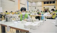  ??  ?? STAYING ON TOP OF DEMAND: Volunteers make face masks at a district office in Seoul, South Korea on Friday.