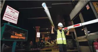  ??  ?? PLUS personnel Mohd Amirul Fahmi Samsul 23, removing a boom barrier after the Batu Tiga toll plaza was closed at midnight yesterday in Shah Alam.