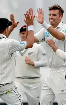  ?? AP ?? Tim Southee acknowledg­es the applause for his half-century, left, and is congratula­ted by team-mates, right, after taking one of his three wickets on the opening day of the second test in Christchur­ch.