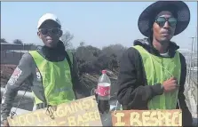  ??  ?? UNITED: Two men taking part in the walk hold posters that show their commitment to fighting genderbase­d violence.