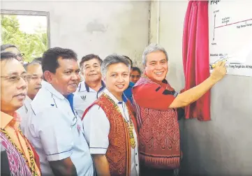  ??  ?? Awang Tengah (right) signing a plaque as a symbolic launch of the RES project at Kampung Danau Krangas. Snowdan is second from right and Dr Rundi on the left.