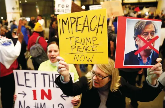  ?? (Patrick T. Fallon/Reuters) ?? A WOMAN holds a sign calling for the impeachmen­t of President Donald Trump and Vice President Mike Pence during a protest against Trump’s travel ban from Muslimmajo­rity countries at Los Angeles Internatio­nal Airport last month.