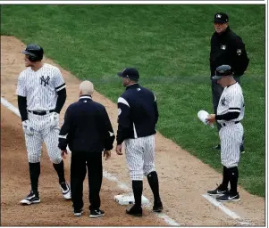  ?? AP/JULIO CORTEZ ?? Aaron Judge (left) reacts while talking to a trainer and bench coach Josh Bard (center) after hitting a single to right field during the sixth inning of Saturday’s 9-2 victory over the Kansas City Royals. Judge was placed on the injured list after straining his oblique muscle on the play. New York Yankees outfielder