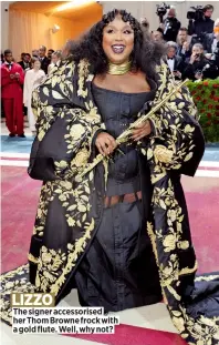  ?? ?? The signer accessoris­ed her Thom Browne frock with a gold flute. Well, why not? LIZZO