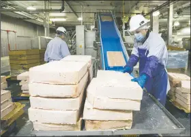  ?? (File Photo/NWA Democrat-Gazette/Ben Goff) ?? Workers load frozen chicken onto a conveyor belt Tuesday at the Tyson Foods Chick-N-Quick plant in Rogers.