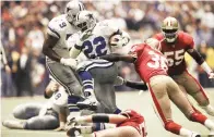  ?? AP Photo/Eric Gay, File ?? ■ Dallas Cowboys running back Emmitt Smith (22) makes his way through San Francisco 49ers' defensive backs Merton Hanks (36) and Bill Romanowski (53), for a 4-yard gain in the second quarter of the Cowboy's 38-21 NFC championsh­ip win Jan. 23, 1994, in Irving, Texas. Few rivalries have had as many big games or star players like Roger Staubach, Joe Montana, Jerry Rice, Emmitt Smith, Deion Sanders, Steve Young, Troy Aikman and Michael Irvin.