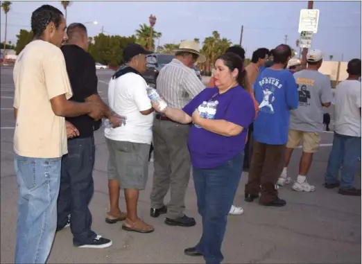  ??  ?? Brown Bag Coalition co-founder Maribel Padilla hands out cold water bottles to the homeless in Calexico during the summertime. PHOTO