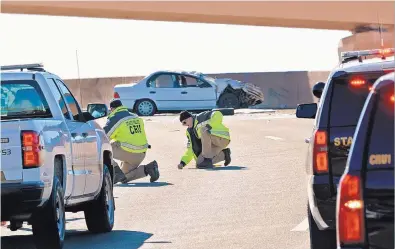  ?? JIM THOMPSON/JOURNAL ?? New Mexico State Police investigat­ors work the scene of a fatal rollover accident on a Big I flyover Friday.