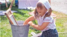  ?? FOTO: VERANSTALT­ER ?? Waschen mit dem Waschbrett: Kinder können diese alten Techniken beim Handwerker­markt ausprobier­en.