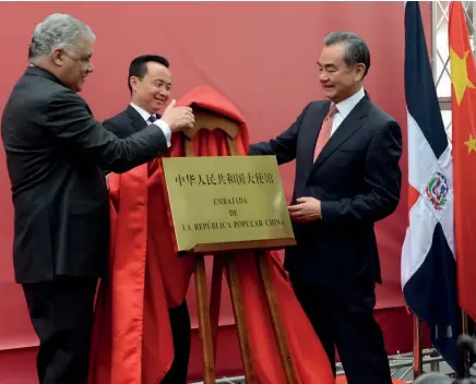  ??  ?? El canciller Miguel Vargas Maldonado y su homólogo de la República Popular China, Wang Yi, develizan la tarja para dejar inaugurada la embajada china en República Dominicana. Observa el embajador de la nación asiática, Zhang Run.