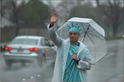  ??  ?? Waver Ian Fujino,17, waves to passing cars in a pouring rain on Friday to promote Liberty Tax services on Lyons Avenue in Newhall.
Dan Watson/The
Signal (See additional photos on signalscv.com)