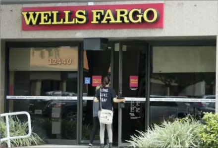 ?? AP PHOTO/LYNNE SLADKY, FILE ?? Customers walk into a Wells Fargo bank in Pembroke Pines, Fla.