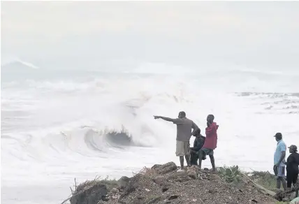  ??  ?? > People gathered on the coast around Jamaica to watch the massive rolling waves produced as Hurricane Matthew hurtled through parts of the Caribbean yesterday