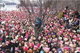  ??  ?? Julie Valente of Emeryville holds her sign high during a rally before the Women’s March in Washington, D.C. Thousands of women in a sea of pink cat hats, knitted in response to comments by President Trump, rally in Washington to send a warning message...