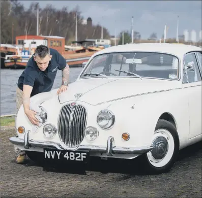  ?? PICTURES: BRUCE ROLLINSON ?? CLASSIC VEHICLES: Main, Dean Swales gives the 1968 Jaguar 240 a polish – it only has 60,460 miles on its clock; above left, Andy Spicer with the rare 1966 Ducati Mach 1 which was restored by a retired policeman; inset, Mark Knowles and a selection of garage signs.